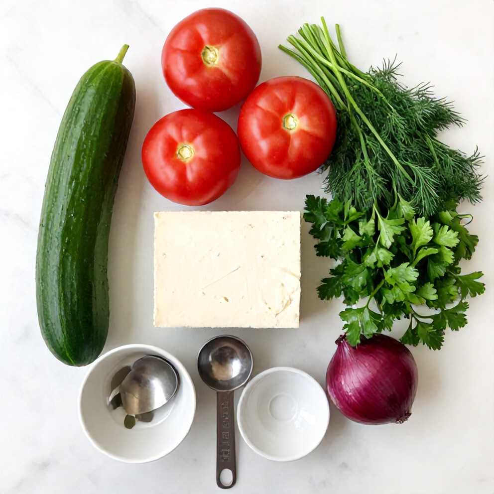 Cucumber, tomato, feta, red onion, fresh herbs on a wooden surface