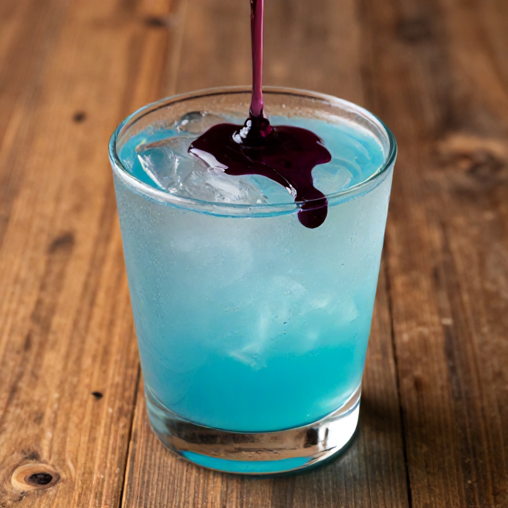 Blueberry syrup drizzled over a glass of lemonade