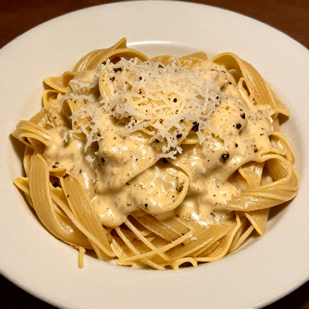Pasta with homemade alfredo sauce, grated parmesan on top